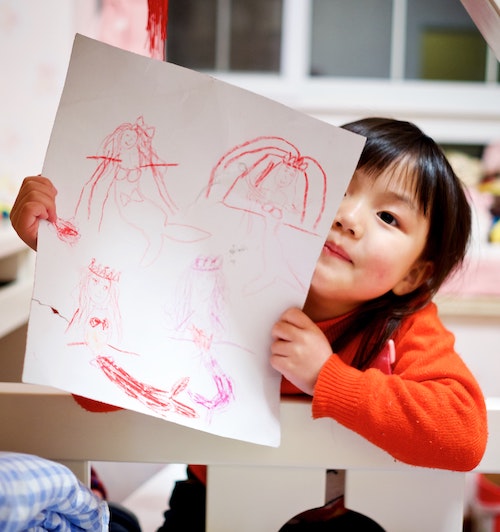 child holding up artwork